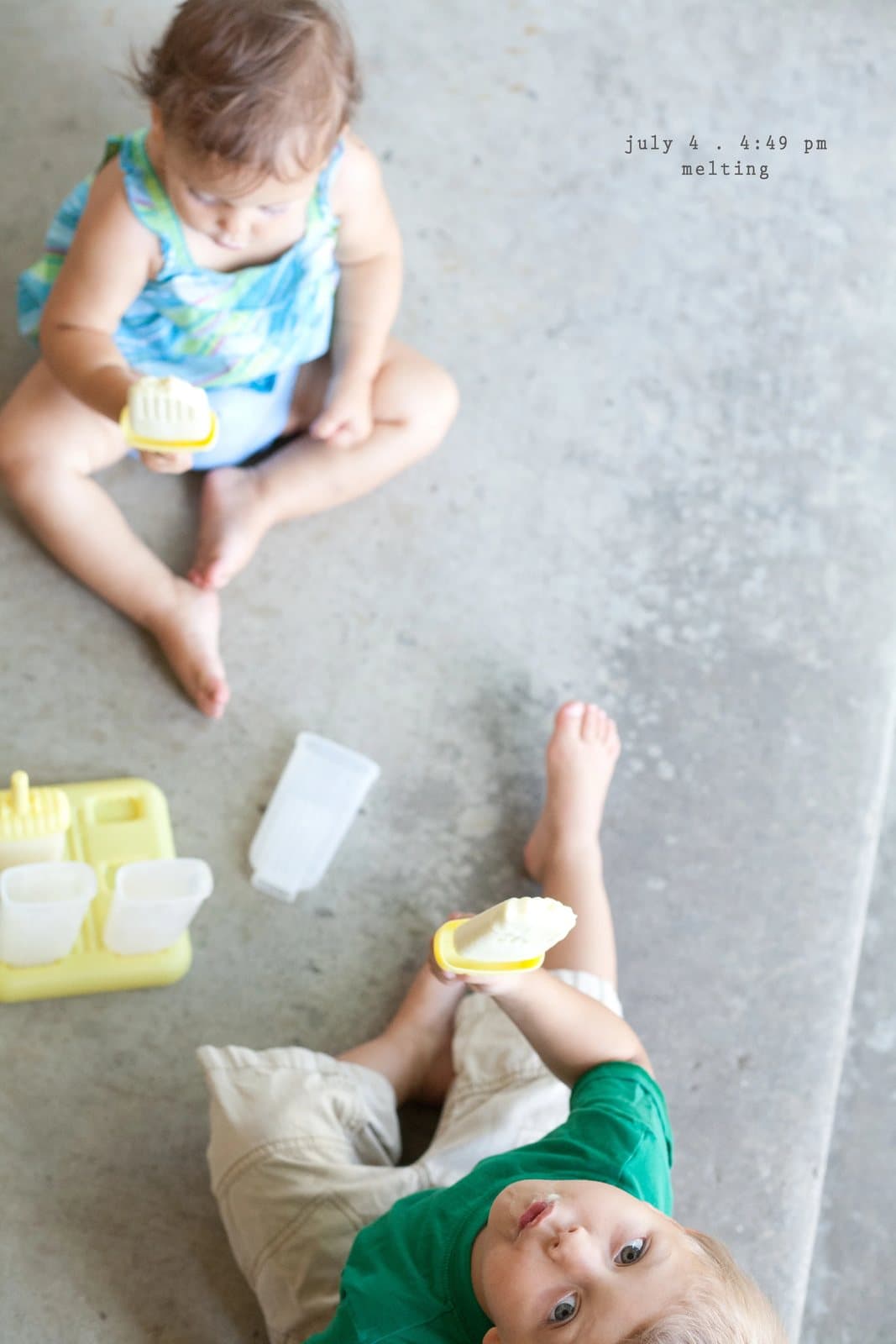 Two children sit on concrete holding ice pops, captioned melting.