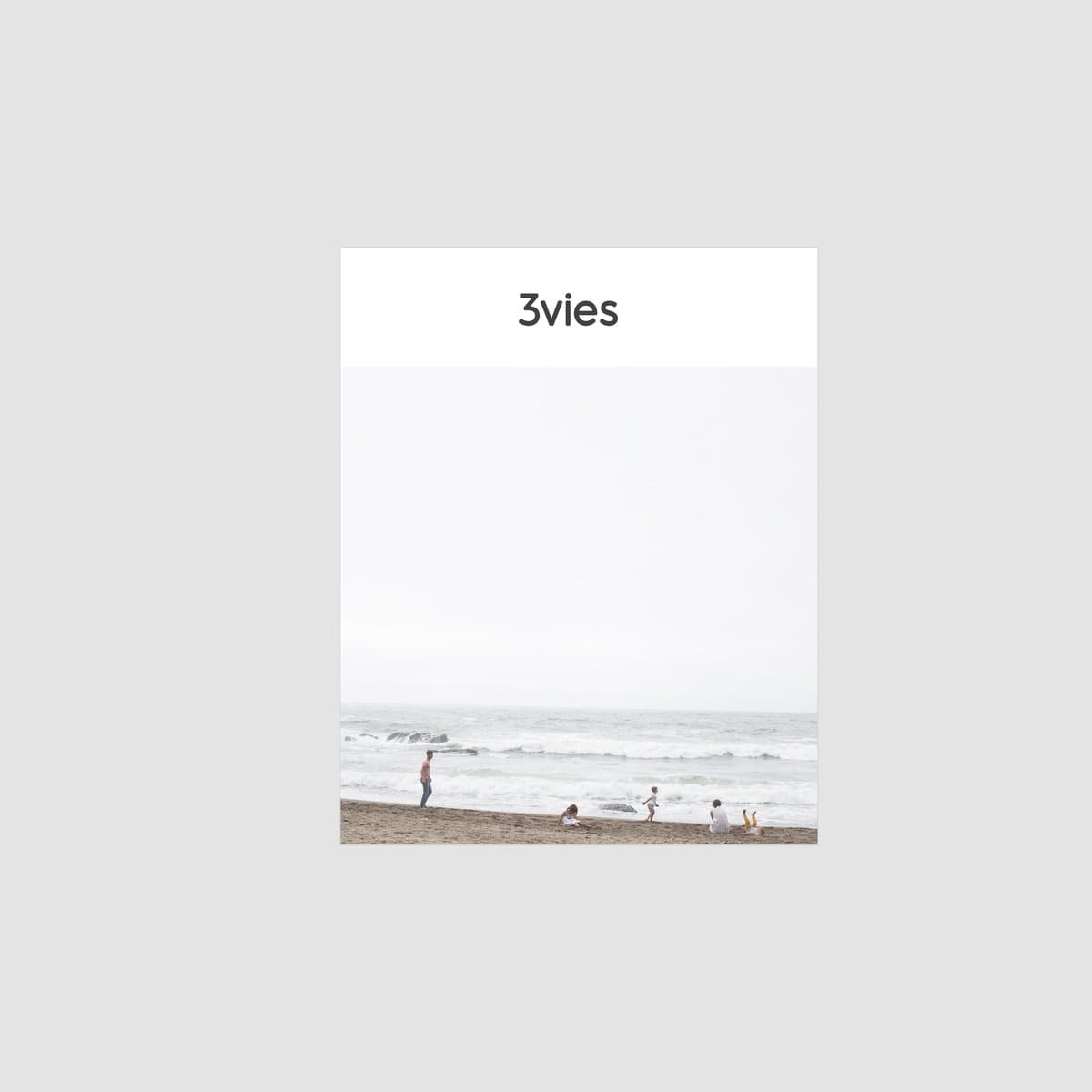 Cover of 3vies Volume 31, a family playing at the edge of a misty ocean beach.