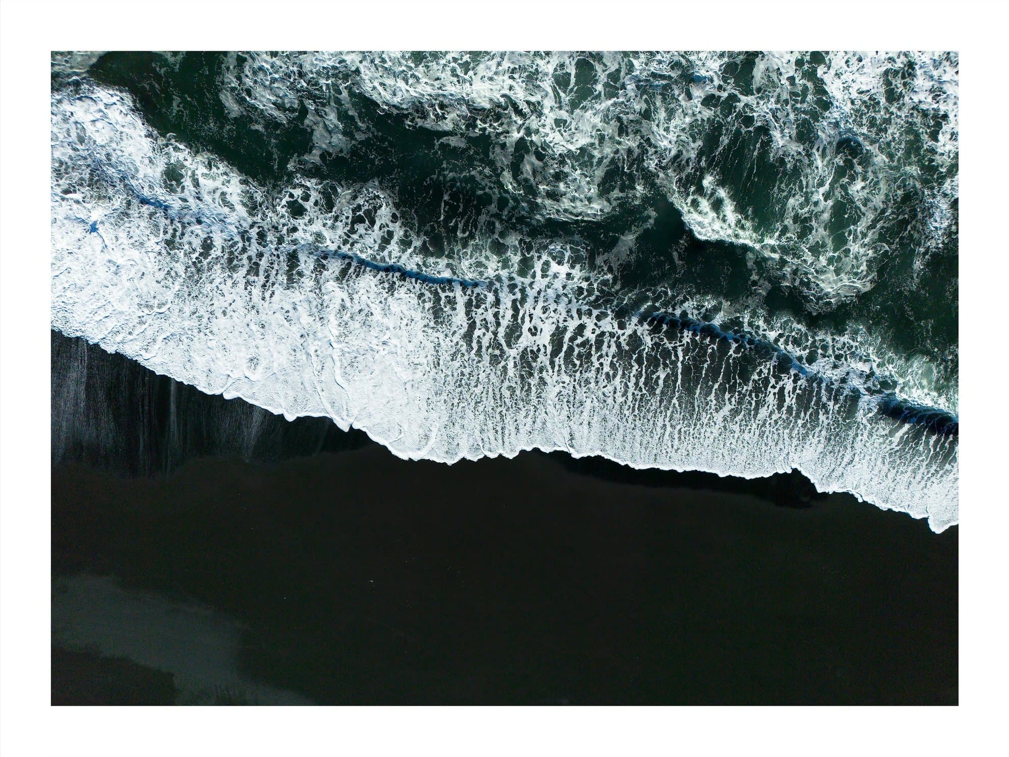Aerial view of white surf breaking over a black sand beach, TIMELESS print Iceland Black Sands.