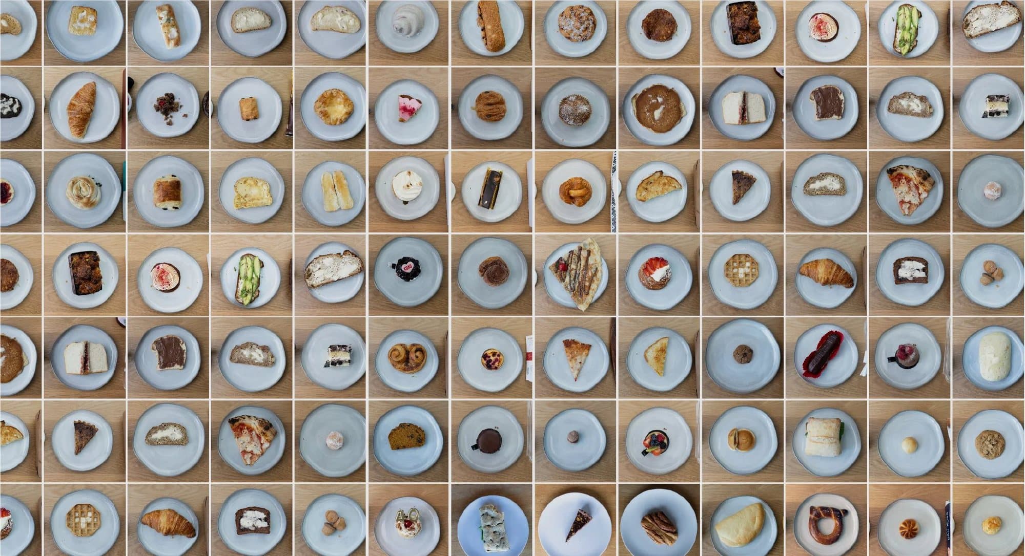 An overhead grid of plated breads, pastries, pies, and cookies from the Gonna Eat Bread series.