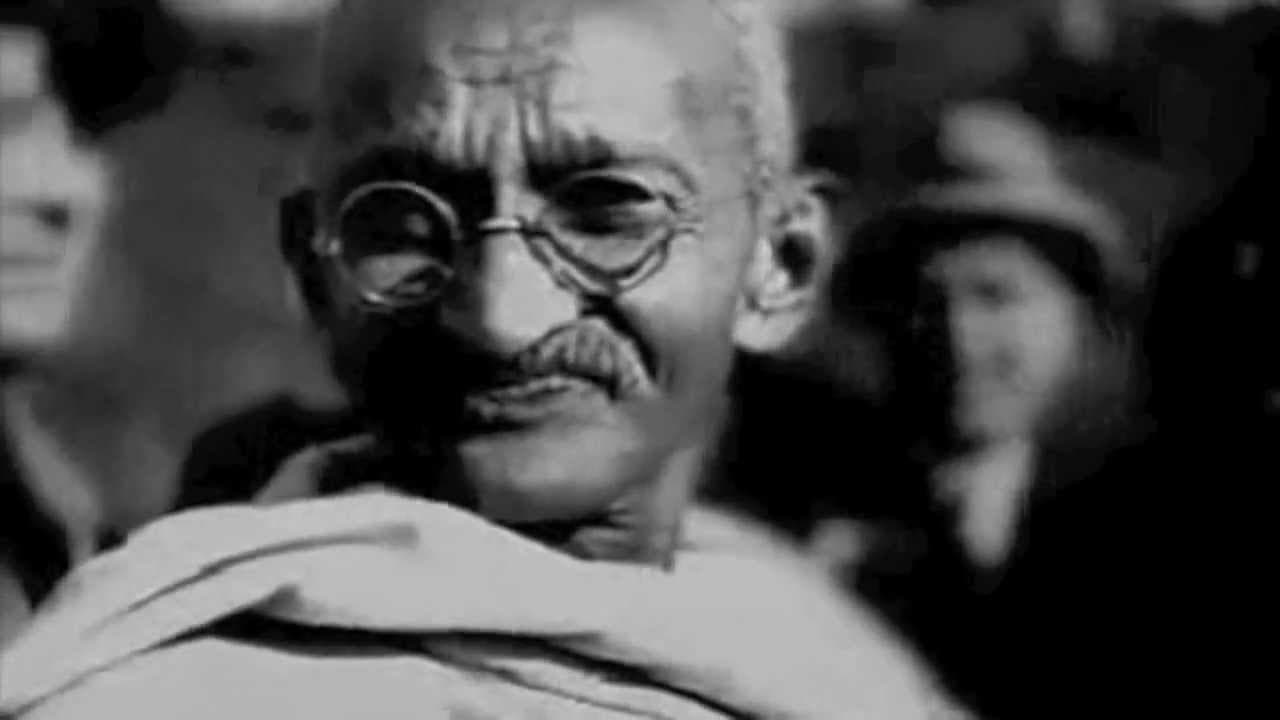 Mahatma Gandhi smiling, in a black-and-white still from the ad.