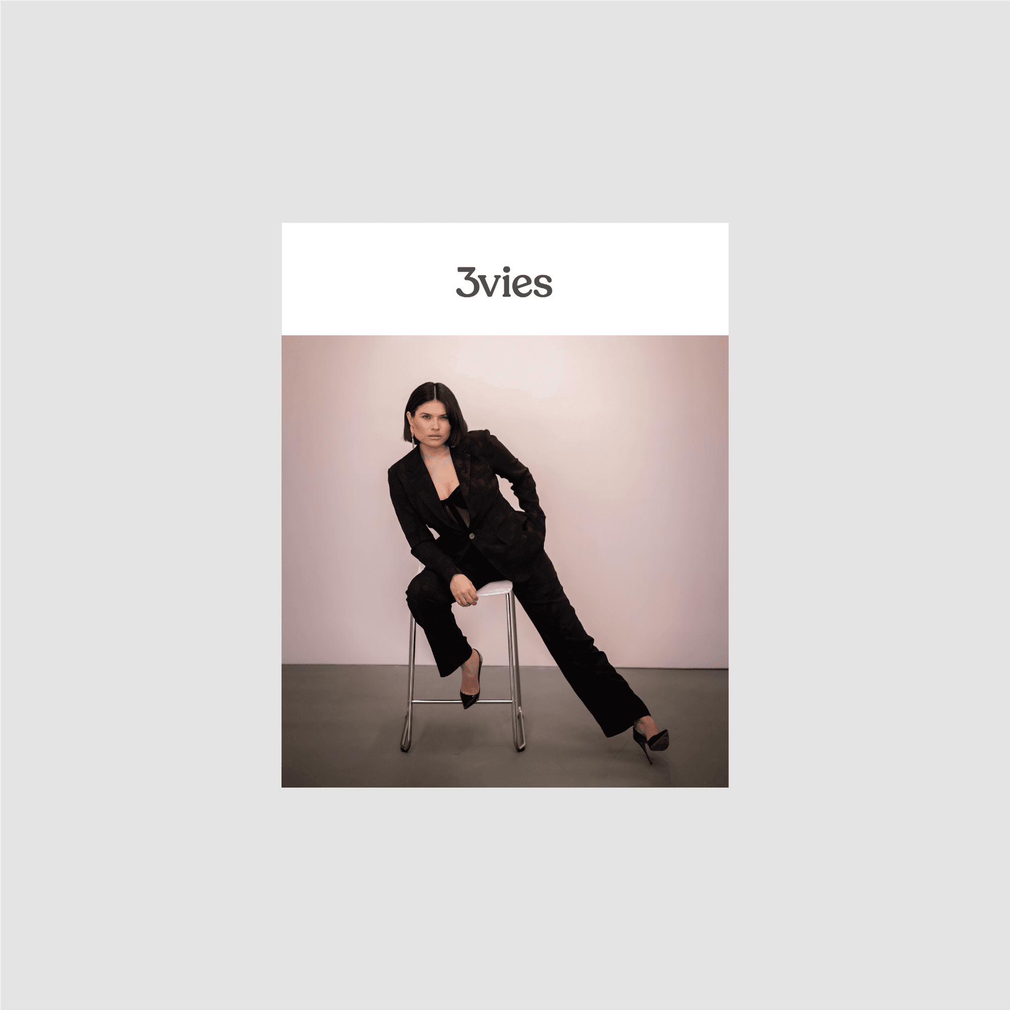 Mockup of the Volume 37 cover, Grecia Valencia seated in a black suit, on a gray background.
