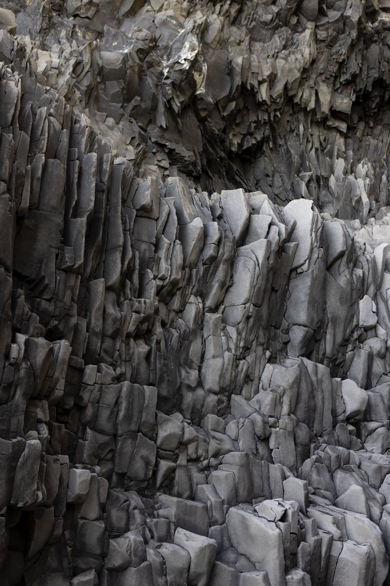 Gray basalt columns stacked along an Icelandic cliff.