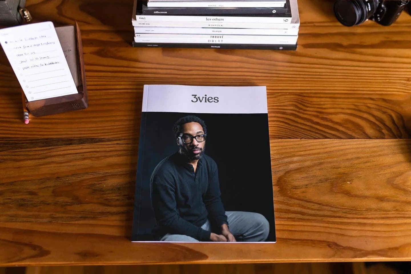 Instagram preview of Volume 35 on a wooden desk beside stacked magazines and a camera.